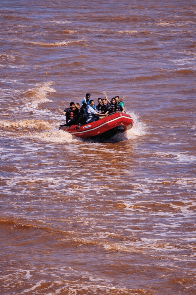 Zodiac raft riding tidal bore waves on the Shubenacadie River during a Fundy tidal bore rafting tour in Nova Scotia