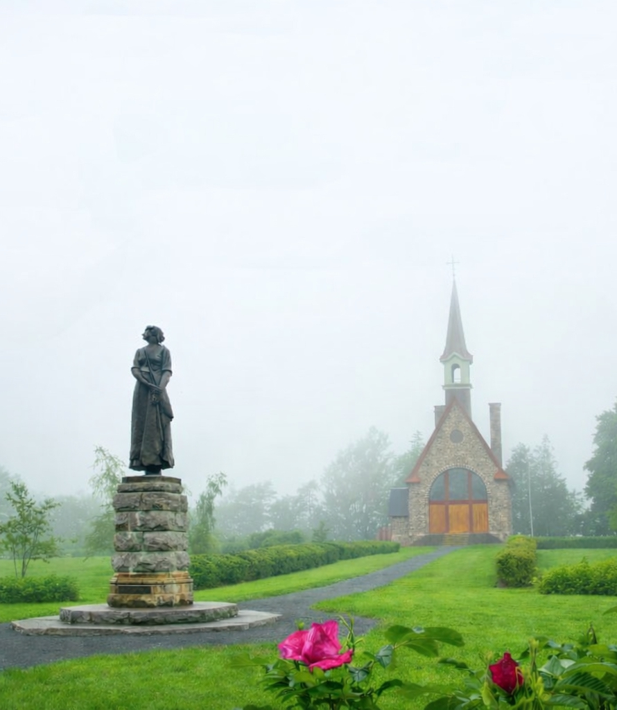 Evangeline statue and Memorial Church at Grand-Pré National Historic Site in the Annapolis Valley, Nova Scotia on a misty morning