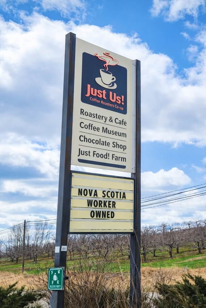 Roadside sign for Just Us! Coffee Roasters Co-op café and roastery in Grand Pré, Nova Scotia