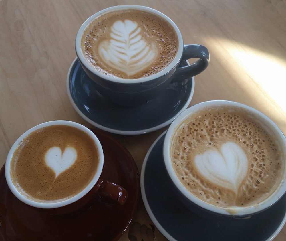 Lattes with heart latte art at Just Us! Grand Pré Café before a Cape Split hike in Nova Scotia