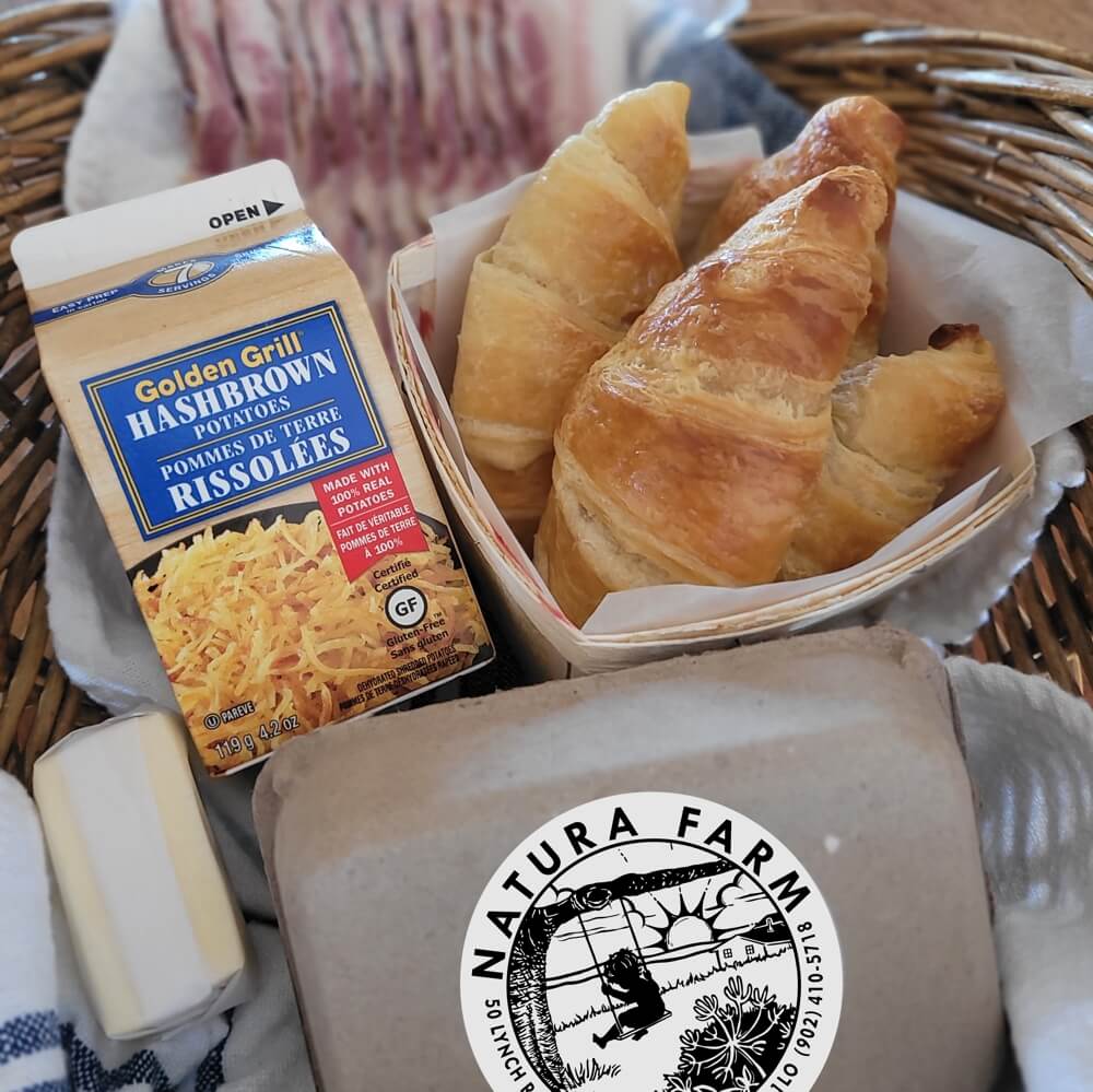 Breakfast basket with fresh eggs, bacon, and croissants ready for cooking