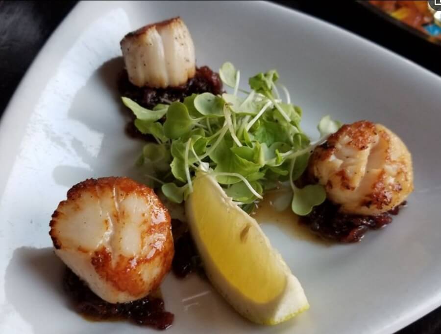 Seared scallops with greens served at The Port Pub in Port Williams, Nova Scotia